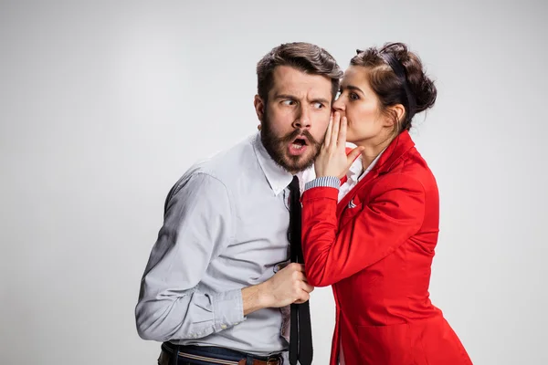 Young man telling gossips to his woman colleague at the office — Stock Photo, Image