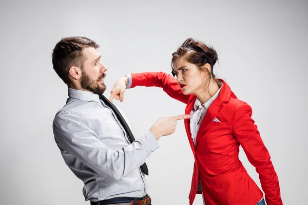 Злий бізнесмен і жінка конфліктують на сірому фоні — стокове фото