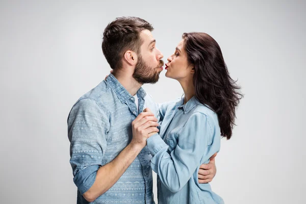 Portrét šťastnému páru na šedém pozadí — Stock fotografie