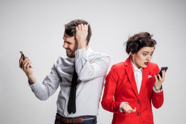 İş kavramı. Cep telefonu gri arka plan üzerinde tutan iki genç arkadaşları