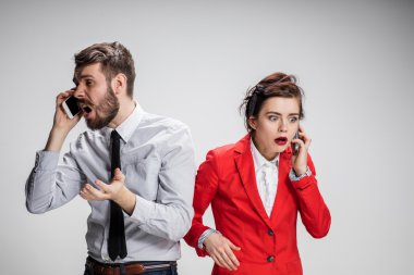 İş kavramı. Cep telefonu gri arka plan üzerinde tutan iki genç arkadaşları