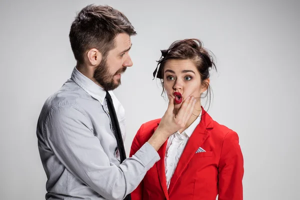 L'homme d'affaires en colère et la femme en conflit sur un fond gris — Photo