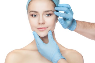 Plastik cerrahi kavramı. Doktor kadın yüz dokunmadan eldiven eller