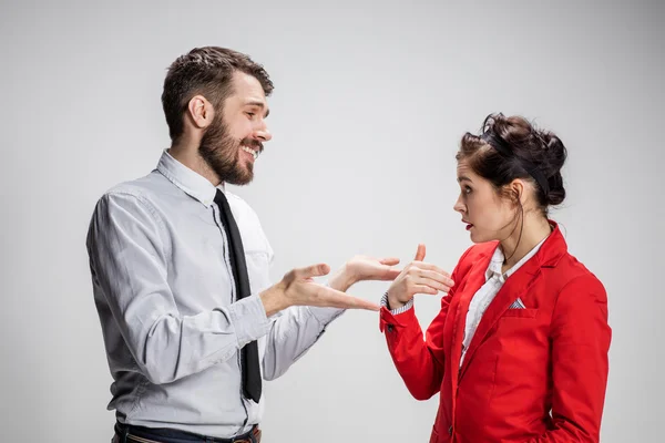 De zakenman en de vrouw communiceren op een grijze achtergrond — Stockfoto