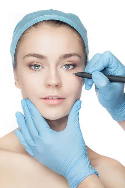Mooie jonge vrouw met perforatie lijnen op haar gezicht voor plastische chirurgie bedienen. — Stockfoto