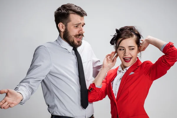 El hombre y la mujer de negocios que se comunican sobre un fondo gris — Foto de Stock