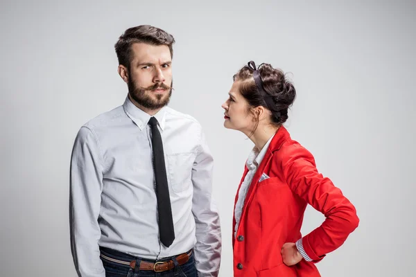 L'uomo e la donna d'affari in conflitto su uno sfondo grigio — Foto Stock