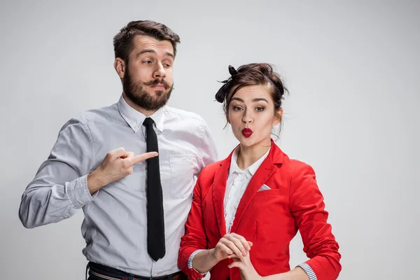 El hombre y la mujer de negocios que se comunican sobre un fondo gris —  Fotos de Stock