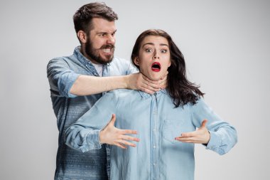 The quarrel men and women. Man strangling a woman on gray background clipart