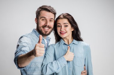 İki genç gülümseyen insanlar başparmak-up hareketi ile