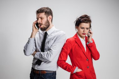 İş kavramı. Cep telefonu gri arka plan üzerinde tutan iki genç arkadaşları