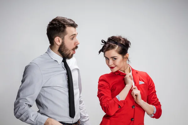 El hombre y la mujer de negocios que se comunican sobre un fondo gris —  Fotos de Stock