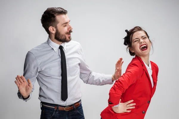 De zakenman en de vrouw communiceren op een grijze achtergrond — Stockfoto