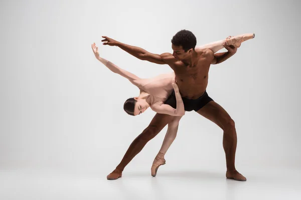 Ein paar Balletttänzer posieren vor grauem Hintergrund — Stockfoto