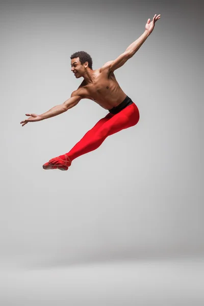 Jovem e elegante moderno bailarino de balé em fundo cinza — Fotografia de Stock