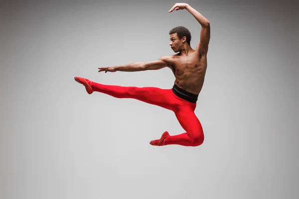 Jovem e elegante moderno bailarino de balé em fundo cinza — Fotografia de Stock