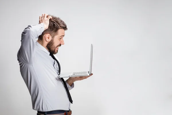 El joven sorprendido hombre con su ordenador portátil — Foto de Stock