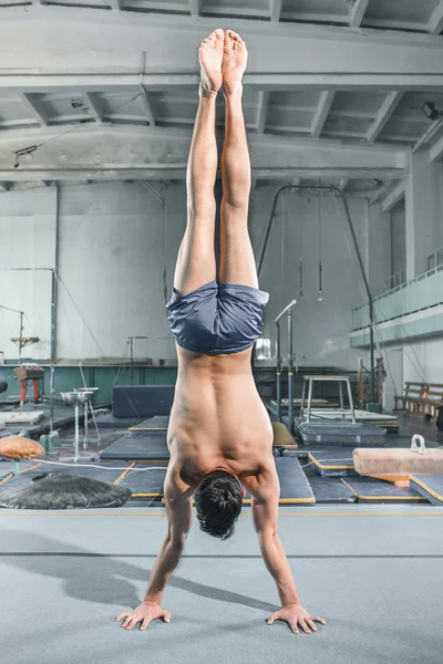 Kaukasischer Mann Gymnastik Akrobatik Gleichgewichtsstellung im Fitnessstudio Hintergrund — Stockfoto