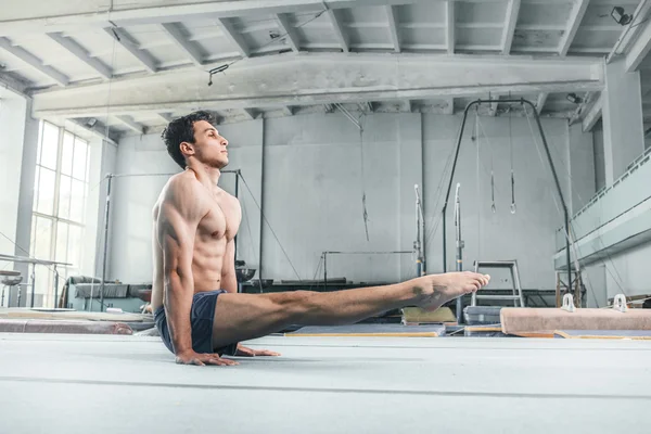 Caucásico hombre gimnasia acrobacias equilibrio postura en gimnasio fondo —  Fotos de Stock