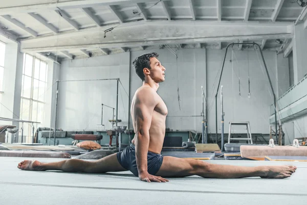 caucasian man gymnastic acrobatics equilibrium posture at gym background