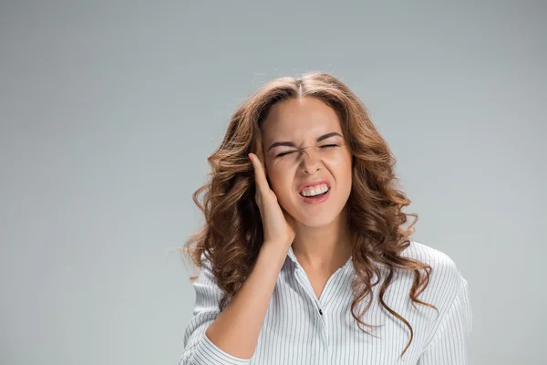 Kulak ağrısı gri üzerinde genç kadınla