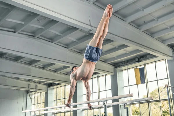 Gimnasta masculino haciendo handstand en barras paralelas —  Fotos de Stock