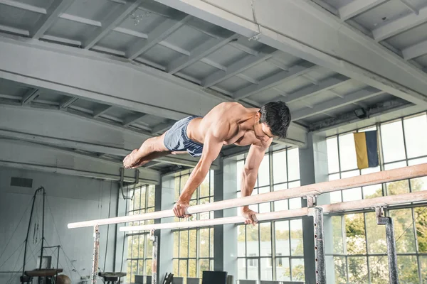 Чоловіча гімнастка виконує ручку на паралельних брусках — стокове фото