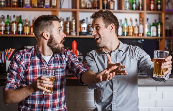 Jovens com cerveja assistindo futebol em um bar — Fotografia de Stock