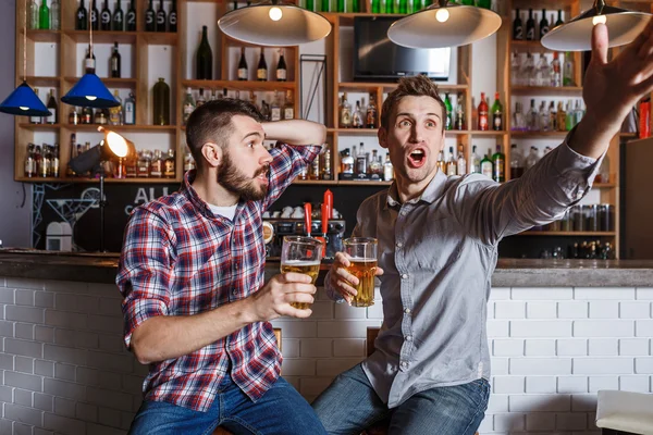 Jonge mensen met bier voetbal in een bar kijken — Stockfoto