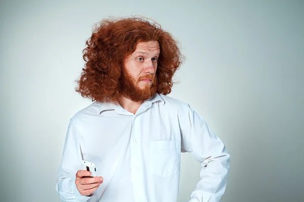 Retrato del hombre desconcertado hablando por teléfono un fondo gris — Foto de Stock