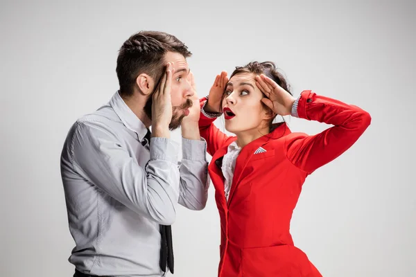 El hombre y la mujer de negocios que se comunican sobre un fondo gris — Foto de Stock