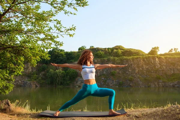 Jeune femme pratique le yoga près de la rivière — Photo