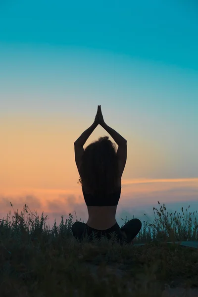 Genç kadın silüeti pratik yoga — Stok fotoğraf