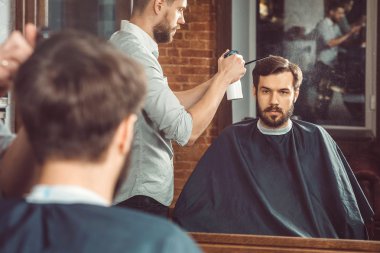 Genç yakışıklı Kuaför berber içinde çekici adamın saç kesimi yapma