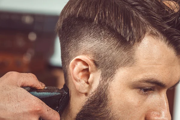 Las manos del joven peluquero haciendo corte de pelo a un hombre atractivo en la barbería — Foto de Stock