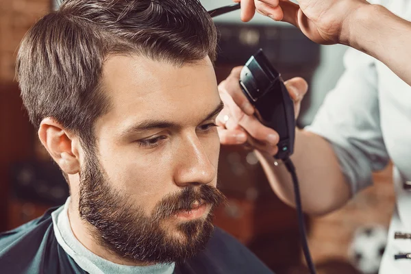 Las manos de joven peluquero haciendo corte de pelo atractivo hombre en la barbería — Foto de Stock