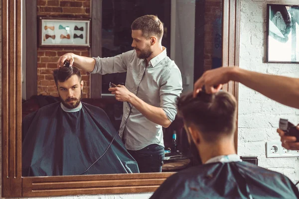Junge hübsche Friseurin macht Haarschnitt von attraktiven Mann in Friseursalon — Stockfoto
