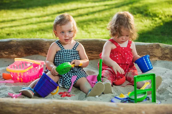 Las dos niñas jugando juguetes en la arena — Foto de Stock