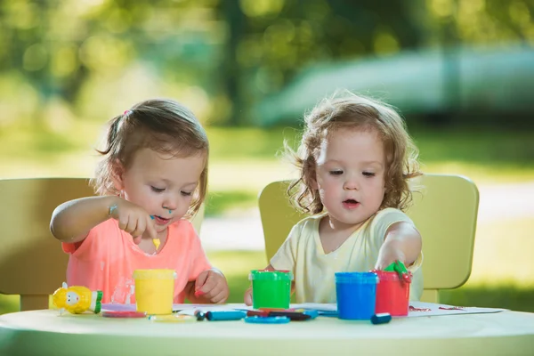 Dos años de edad, las niñas pintando con pinturas de póster juntos contra el césped verde — Foto de Stock