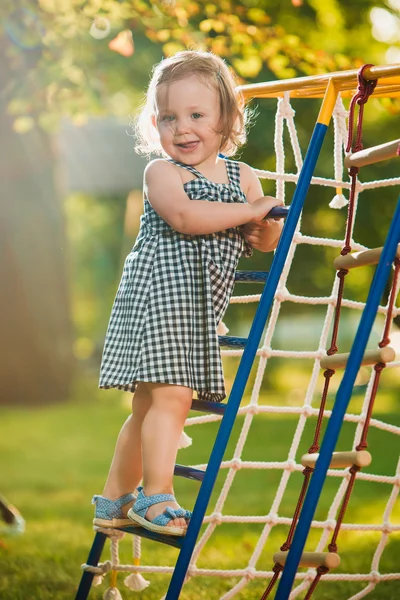 A menina brincando no playground ao ar livre — Fotografia de Stock