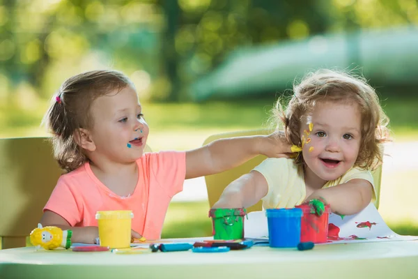 Dos años de edad, las niñas pintando con pinturas de póster juntos contra el césped verde — Foto de Stock