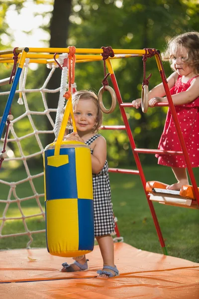 As duas garotinhas brincando no playground ao ar livre — Fotografia de Stock