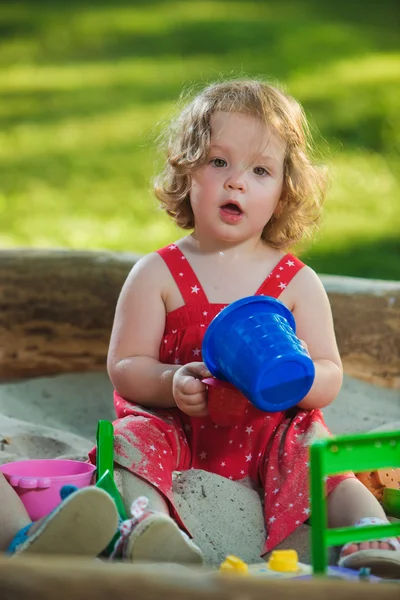 Маленька дівчинка грає в іграшки на піску — стокове фото