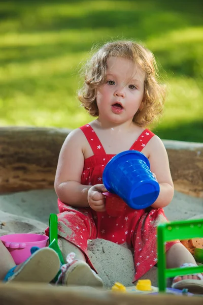 La petite fille jouant des jouets dans le sable — Photo