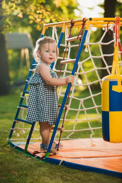 La pequeña niña jugando en el patio al aire libre — Foto de Stock
