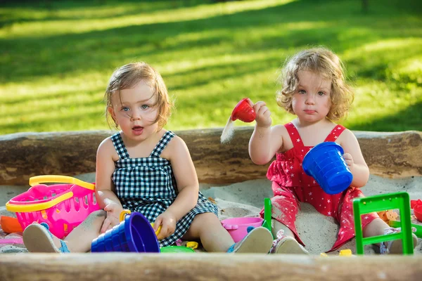 Två lite baby flickor leker leksaker i sand — Stockfoto