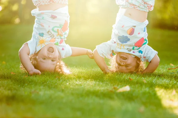 Las dos niñas colgando boca abajo — Foto de Stock