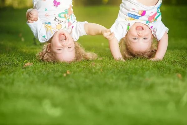 Las dos niñas colgando boca abajo — Foto de Stock