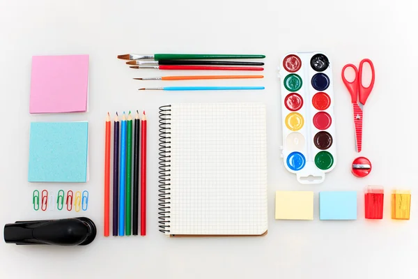 Conjunto escolar con cuadernos, lápices, pincel, tijeras y manzana sobre fondo blanco — Foto de Stock