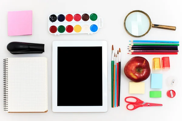 Школьный набор с ноутбуками, карандашами, кисточкой, ножницами и яблоком на белом фоне — стоковое фото